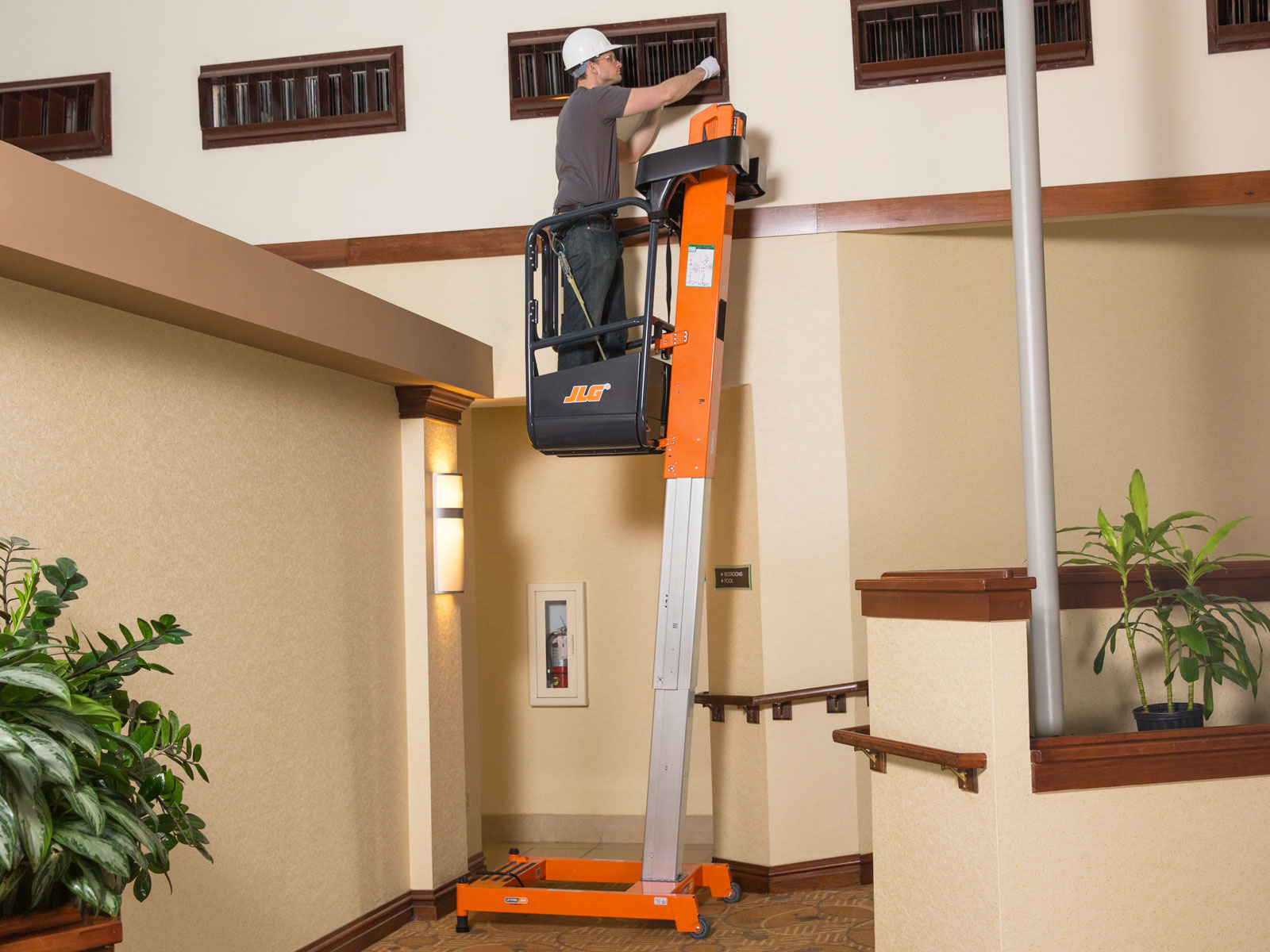 Trabajador realizando un trabajo en altura con la plataforma personal JLG distribuidas por OZMAQ que prácticamente no requieren mantenimiento, no utilizan cables ni cadenas para lograr una mayor rigidez.