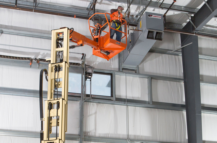 Operario realizando un trabajo en altura en una plataforma elvadora tipo toucen de la marca JLG distribuida por OZMAQ en Querétaro, San Luis Potosí, Aguascalientes, Irapuato y Laguna.